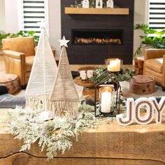 a living room decorated for christmas with candles and decorations on the coffee table in front of the fireplace