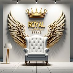 a white chair sitting in front of a wall with gold wings and a crown on it