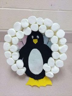 a paper plate penguin with marshmallows in the shape of a circle on it