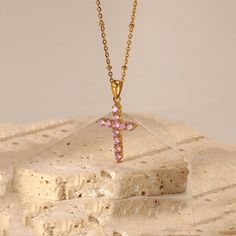 Looking for a cross necklace that's both pretty and versatile? The Pink Cross Necklace is the perfect choice for you! Adorned with lovely pink stones and set on a stylish gold beaded chain, this dainty necklace is a showstopper. Whether you wear it alone or pair it with other necklaces, it's sure to add a touch of elegance to any outfit. This can is made of stainless steel, so waterproof! The color remains perfect. Gold: 18k gold platingLength: 43+5cmMaterial: Stainless steel Waterproof jewelry Pink Cross Pendant Necklace For Gift, Pink Cross Necklace For Gift, Pink Cross Necklace For Gifts, Rose Gold Plated Cross Pendant Necklace, Rose Gold Plated Cross Necklace, Pink Cross Necklace, Pink Zircon, Pink Cross, Stainless Steel Chain Necklace