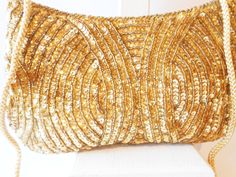 "A gold beaded evening bag with lots of glamour. This vintage bag has a background of gold satin with gold sequins and beads. It has a snap closure. The sequin evening bag has a gold taffeta interior and includes one small pocket. This is a glamorous gold beaded clutch bag plus it includes a gold cord strap to wear on your shoulder or cross body. This gold bead clutch has a lot of sparkle. This gold bead bag has lots of glamour just for you. A perfect party bag or cocktail purse. MATERIAL: Sequi Gold Sequined Bags For Party, Gold Sequined Party Bag, Gold Sequin Party Bag, Gold Party Bags With Sequins, Gold Sequin Bags For Gifts, Gold Sequined Bags As Gifts, Gold Sequined Bags For Gifts, Elegant Gold Bags With Sequins, Elegant Gold Sequined Bags