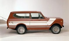 an old red and white station wagon parked in a studio area with no one around