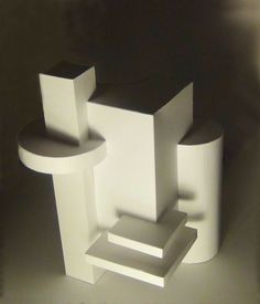 a white sculpture sitting on top of a table next to a black and white wall