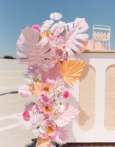 a pink and yellow wedding arch with flowers on it