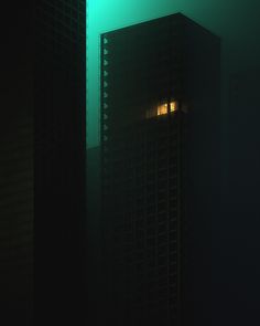 two tall buildings are lit up in the dark with light coming from their windows at night