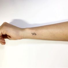 a person's arm with a small tattoo on the left side of their arm