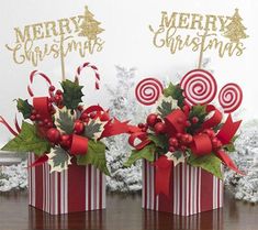 two red and white boxes with candy canes in them on top of a table