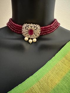 Ruby beads with CZ stones and pearls pendant with matching earrings  choker set Handmade jewelry  Silver-plated jewelry  One gram gold jewelry Official Website globusfashions.com 🌸 S H O P . M O R E . S T Y L E S  🌸 https://www.etsy.com/shop/Globusfashions Necklaces -  https://www.etsy.com/shop/Globusfashions?section_id=18712263 Bracelets - https://www.etsy.com/shop/Globusfashions?section_id=18969767 Pendant Sets - https://www.etsy.com/shop/Globusfashions?section_id=18707402 Tikka - https://www.etsy.com/shop/Globusfashions?section_id=20096802 Bangles - https://www.etsy.com/shop/Globusfashions?section_id=20105376 Anklets - https://www.etsy.com/shop/Globusfashions?section_id=20319051 Hair Clips - https://www.etsy.com/shop/Globusfashions?section_id=20322585 Saree Pins - https://www.etsy.com Party Jewelry With Pearl Pendant And Crystal, Party Pearl Drop Necklace With Cubic Zirconia, Diamond Pearl Drop Jewelry For Party, Party Jewelry With Diamond And Pearl Drop, Party Jewelry With Pearl Pendant And Round Beads, Beaded Cubic Zirconia Jewelry For Party, Party Jewelry With Pearl Chain And Cubic Zirconia, Jeweled Pendant Jewelry For Anniversary, Jeweled Choker Bridal Necklace For Party