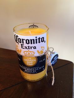 a candle that is sitting on a table next to a can of corona extra beer