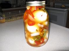 a mason jar filled with pickled vegetables on top of a counter