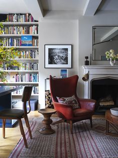 a living room filled with furniture and a fire place in front of a bookshelf