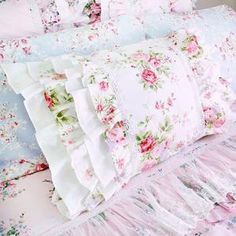 a bed with pink flowers and ruffles on it