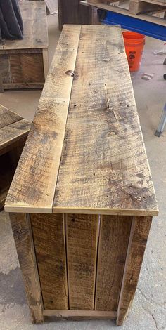 a wooden bench sitting in the middle of a room next to other pieces of furniture