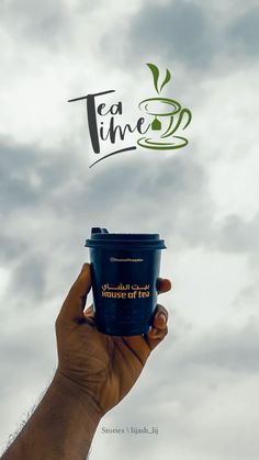 a hand holding up a coffee cup with the words tea time written above it in front of a cloudy sky