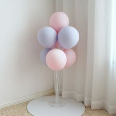 a bunch of balloons sitting on top of a white stand