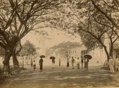 an old black and white photo of people with umbrellas