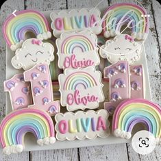 decorated cookies with rainbows and clouds are on a plate next to the word hello