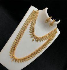 This 22K gold-plated bridal mango necklace jewelry is a beautiful South Indian style combination long and short haram malas. The sets are studded with American diamond-hued crystal stones, rubies, emeralds, and CZ diamonds, giving it a luxurious and eye-catching look. The length of long necklace is 22 inches and  the short necklace is 14 Inches and comes with an adjustable thread extender. Diamond Mango Mala, Mango Mala Jewellery, Mango Mala, Mango Necklace, Long Haram, Mala Jewelry, American Diamond Jewellery, Black Beaded Jewelry, White Stones