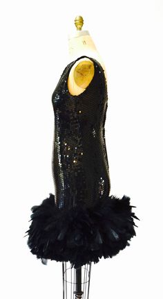 "Breathtaking party dress Black sequins with feathers This lovely features: * Black bodice fully embellished with black sequins * gorgeous super full Feather trim around the hemline * Back zip closure and fully lined * Stunning Dana Deatherage Size Small Synthetic lining Excellent vintage condition Bust 34\" Waist 31\" Hip 37\" Front body length from top of bodice 36\" Visit the shop https://www.etsy.com/shop/Hookedonhoney ** twitter | hookedonhoney ** pinterest | hookedonhoney ** Instagram | ho Fitted Flapper Dress For Club And Party Season, Feathered Flapper Dress For Party, Glamorous Black Sequin Dress For Costume Party, Flapper Dress With Feather Trim For Party Season, Party Season Flapper Dress With Feather Trim, Party Flapper Dress With Feather Trim, Glamorous Flapper Dress With Feather Trim For Party Season, Glamorous Feather Trim Flapper Dress For Party Season, Glamorous Sequin Dress With Feathers For Cocktail