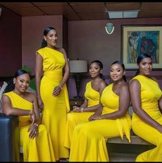 a group of women in yellow dresses posing for the camera with one woman sitting on a couch