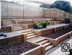 a garden area with steps and plants in the center, surrounded by wood fences