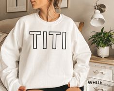 "Titi Sweatshirt for Women, Titi Sweatshirt, Gift for Mothers Day, Best Gift for Titi, Love Heart, Titi Birthday Gift Idea, Titi Sweatshirt for Women HOW TO ORDER: 1. Please, Check and Review all Photos and Size Charts (The V-necks and Tank Tops are Women's Size, and the other styles are Unisex) 2. Choose Your T-Shirt Color/Size (You can see youth and toddler options in the same drop-down menu) 3. Choose Your Quantity as much as you want. 4. Click \"Add To Cart\". For multiple items go back to t Brides Mom, Class Shirt, Party Sweaters, Boho Sweater, Nana Gifts, Bride Gift, Mom Sweatshirt, Teacher Tshirts, Bride Bridal