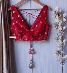 This Made to Order/Made to Measurement/Custom Made Indian Ethnic Blouse. - Fabric - Embroidered Upada Silk - Color - Red - Padded - Princess Cut - Deep V Neck - Rich lining - Sleeveless - Shoulder String with Tassels - Fringes around the waist PLEASE NOTE: This is a made to order product. If you opt for 'Made To Measurement Option', we will provide a measurement template and you can share the measurements likewise. If you want to opt for 'Standard Size', Please refer to the size chart provided i