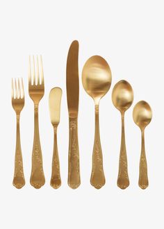 gold colored utensils are lined up in a row on a white background with one fork, two spoons and three knives