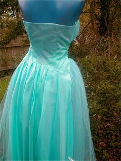 "Turquoise Bridesmaid Gown - Tulle Full Skirt Bustled Strapless with Bolero Jacket and Headpiece Size Small Found in its Original Box from Macys Department store in Philadelphia... T his gown never made it to the altar and reception. Too bad- it's a stunner of a gown! Construct: A Strapless Design- with gathered Tulle over layed. Sashed at the waist, the sash becomes a flowing train - Two pleated panels with extra tulle- give a very pleasing bustled effect at the back. The Dress zips at the side Turquoise Bridesmaid, Bolero Jacket, Bridesmaid Gown, Dec 12, Full Skirt, Halter Formal Dress, Department Store, Headpiece, Philadelphia