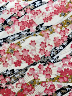 the fabric is very colorful and has pink flowers on black, white, and gold stripes