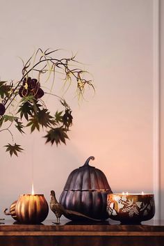 a table topped with two pumpkins and a candle