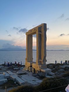 an old stone structure near the ocean at sunset