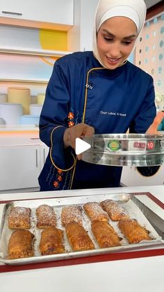 a woman is making pastries in the kitchen