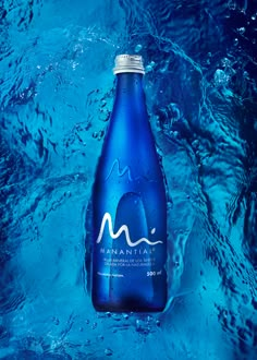 a bottle of mountain water floating in blue water