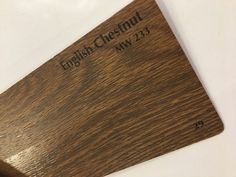 a close up of a wooden sign on a white surface with the words english chestnut