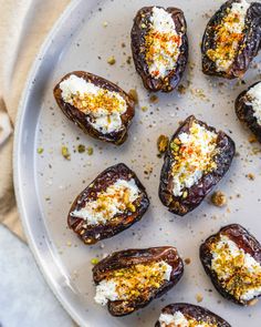 an overhead view of stuffed figs on a plate with cheese and seasoning sprinkles