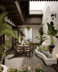 an outdoor dining area with potted plants on the table and several chairs around it