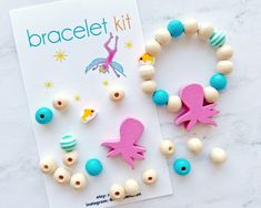 the bracelet kit is made with wooden beads and plastic fish charms, along with an instruction book