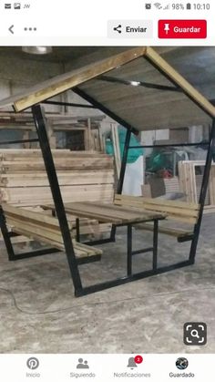 two benches made out of wooden planks in a building with metal frames and windows