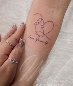 a woman's arm with a tattoo that says love yourself and two hearts on it