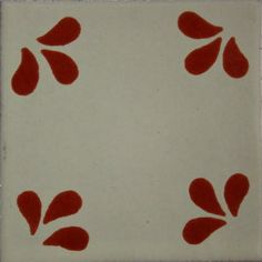 a red and white tile with some leaves on it