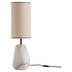 a white marble lamp with a beige shade