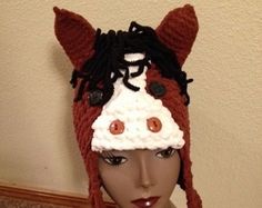 a mannequin head wearing a knitted hat with buttons on it's ears