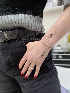 a woman's hand with a small tattoo on her left wrist and the moon