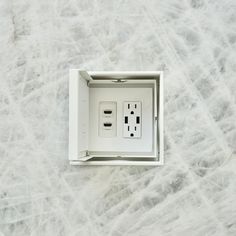 an electrical outlet in the middle of a white wall with two wires attached to it