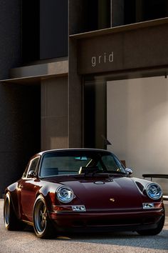 a red sports car parked in front of a building with the word grid written on it