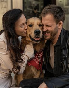 a man and woman sitting next to a dog