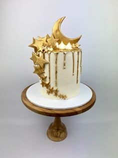 a white and gold cake with stars on top