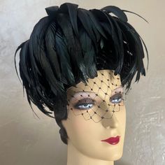 This Is A Sample Of The Most Fashionable Millinery Creations Using Iridescent Rooster Feathers, The Hat Consists Ion A Round Structure That Sits On Top Of The Head. From The Top There Is A Voluminous Cascade Of Long Black Rooster Feathers That Frame The Face And Head. At The Top Center, There Is A Small Rhinestone Jewel. There Is Also A Black Demi-Veil. In The 1950s, Hat Designers Made Hats That Covered Up The Entire Head. They Were Covered In Feathers, Fur, Flowers, Or Manipulated Fabrics. Thes Black Feathered Short Brim Costume Hat, Fitted Black Fascinator With Feather Trim, Vintage Black Kentucky Derby Costume Hat, Adjustable Black Fascinator For Vintage Events, Black Brimmed Mini Hats For Vintage Events, Fitted Black Headpiece For Vintage Events, Black Mini Hat With Feathers And Curved Brim, Vintage Black Hat For Costume Party, Vintage Black Costume Hats For Halloween