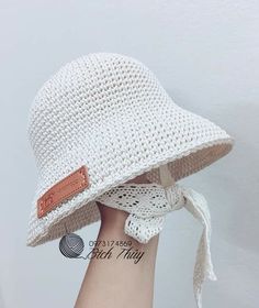 a woman's hand with a white hat on it